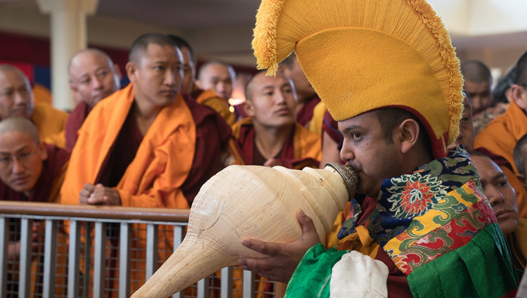 A monk playing a traditional horn escorting His Holiness the Dalai Lama to the the teaching throne at the Tsuglagkhang courtyard in Dharamsala, HP, India on March 12, 2017. Photo by Tenzin Choejor/OHHDL