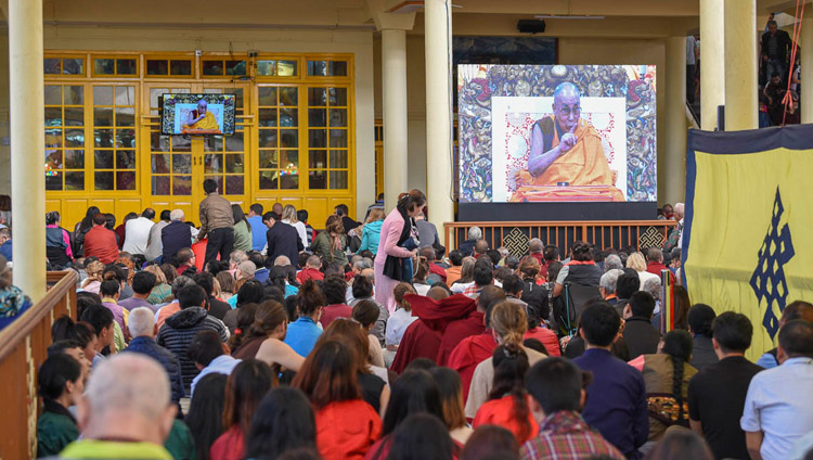 मुख्य तिब्बती मंदिर के प्रांगण में एकत्रित लोगों में से कई परम पावन दलाई लामा के प्रवचनों को बड़े परदे पर देखते हुए, धर्मशाला, हि. प्र., भारत, अक्टूबर ३, २०१८  चित्र/तेनज़िन फेन्दे/डीआईआईआर